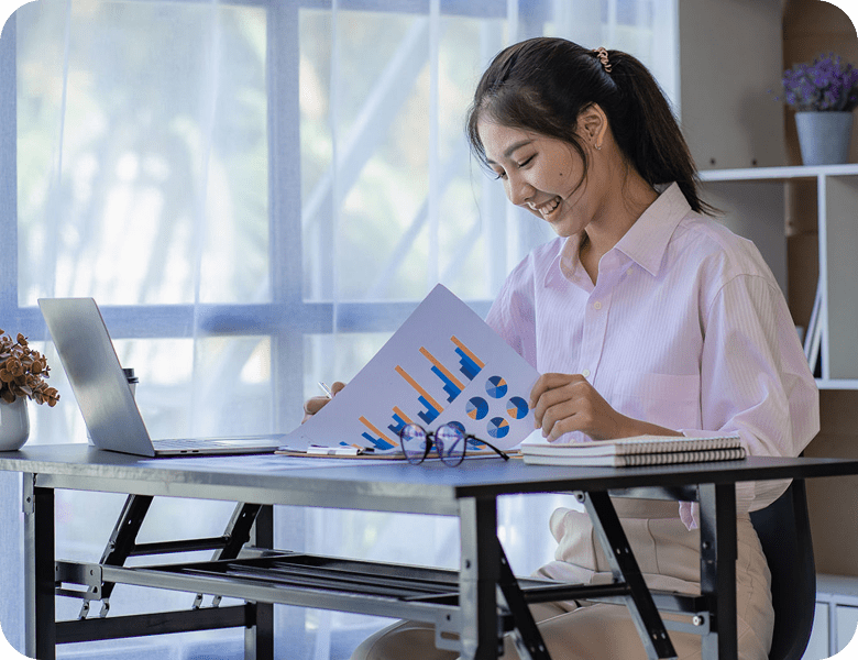 Woman analyzing charts at a desk.