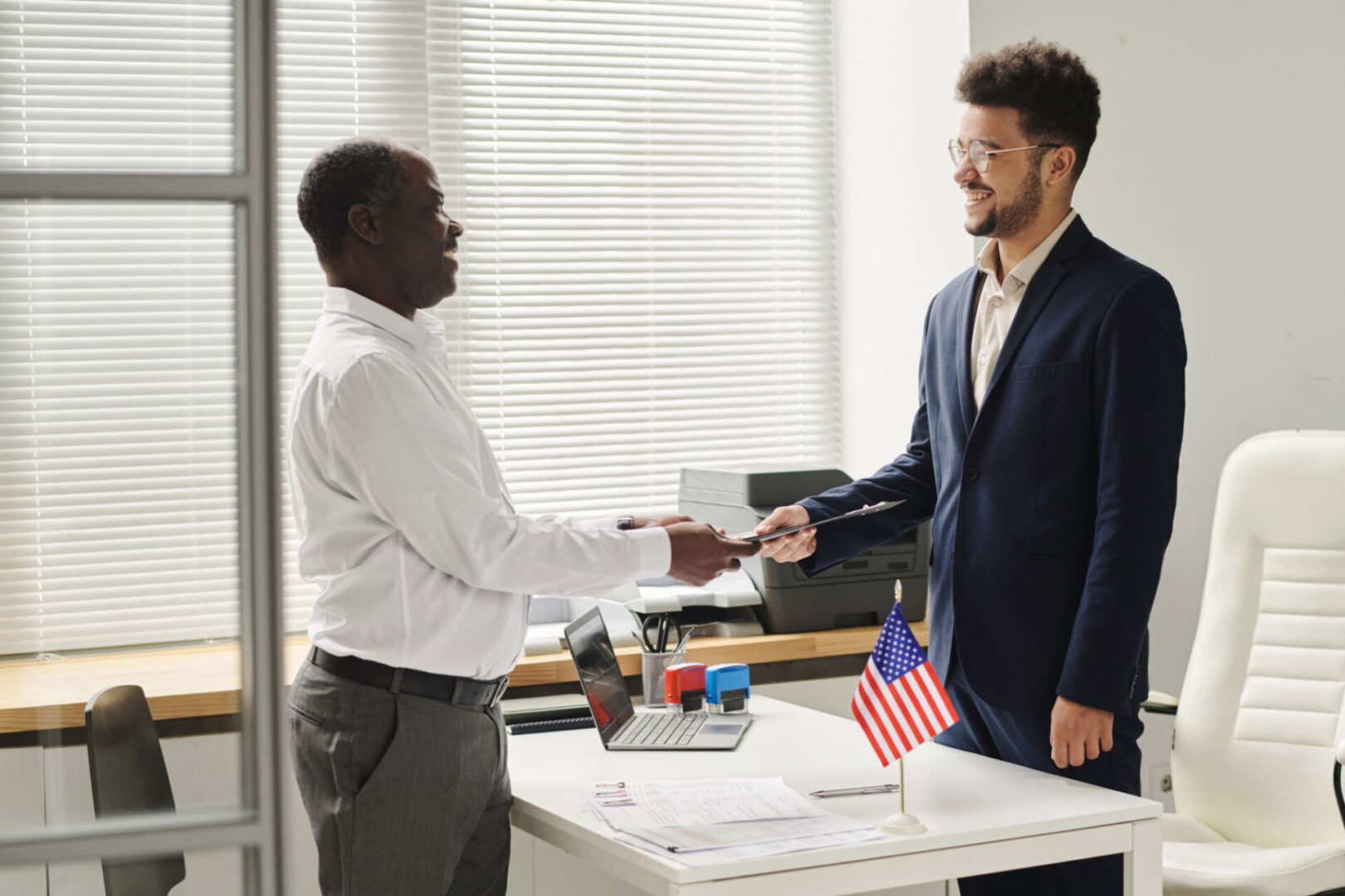 Two men shaking hands in an office.